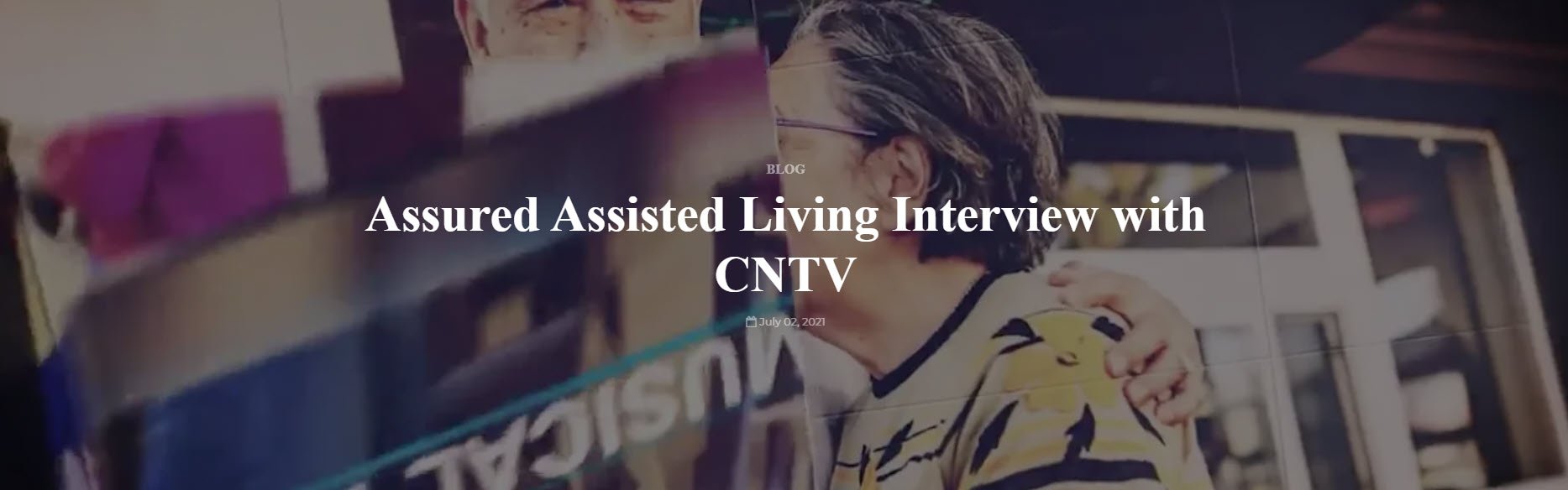 Two people stand together, one with an arm around the other, in front of a glass door. Text overlay reads, "Assured Assisted Living Interview with CNTV." This heartfelt Assisted Living Interview captures their close connection.